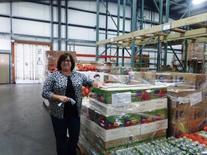 Andrea Todd, executive assistant at Coastal Harvest, stands next to a food that will soon be delivered. Photo courtesy of Rachel Ayres.