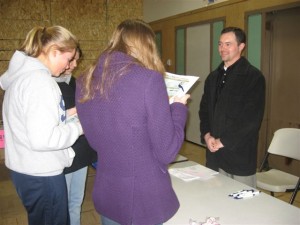 A Great Northwest Federal Credit Union representative chats with youth during a financial workshop.