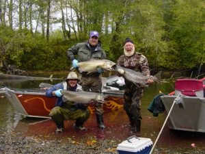 Three fishermen pose with their fish.
