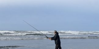 man casting his fishing rod in the ocean