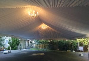 big white party tent with chandeliers hanging from it