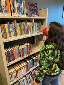 Youth browsing books at Hawks Prairie Timberland Regional Library
