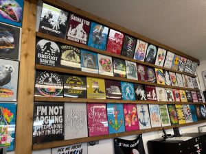 wall of tshirt designs in frames at Too Cool Sportswear in Ocean Shores