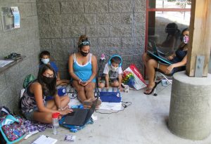 people sitting on the ground outside a Timberland Regional Library using their computers