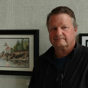 Tom Rossow standing next to one of his paintings on a wall