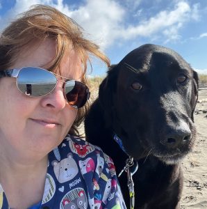 Larina Boyd with her black lab, Nala at the beach