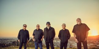 Los Lobos band standing in the desert at sunset