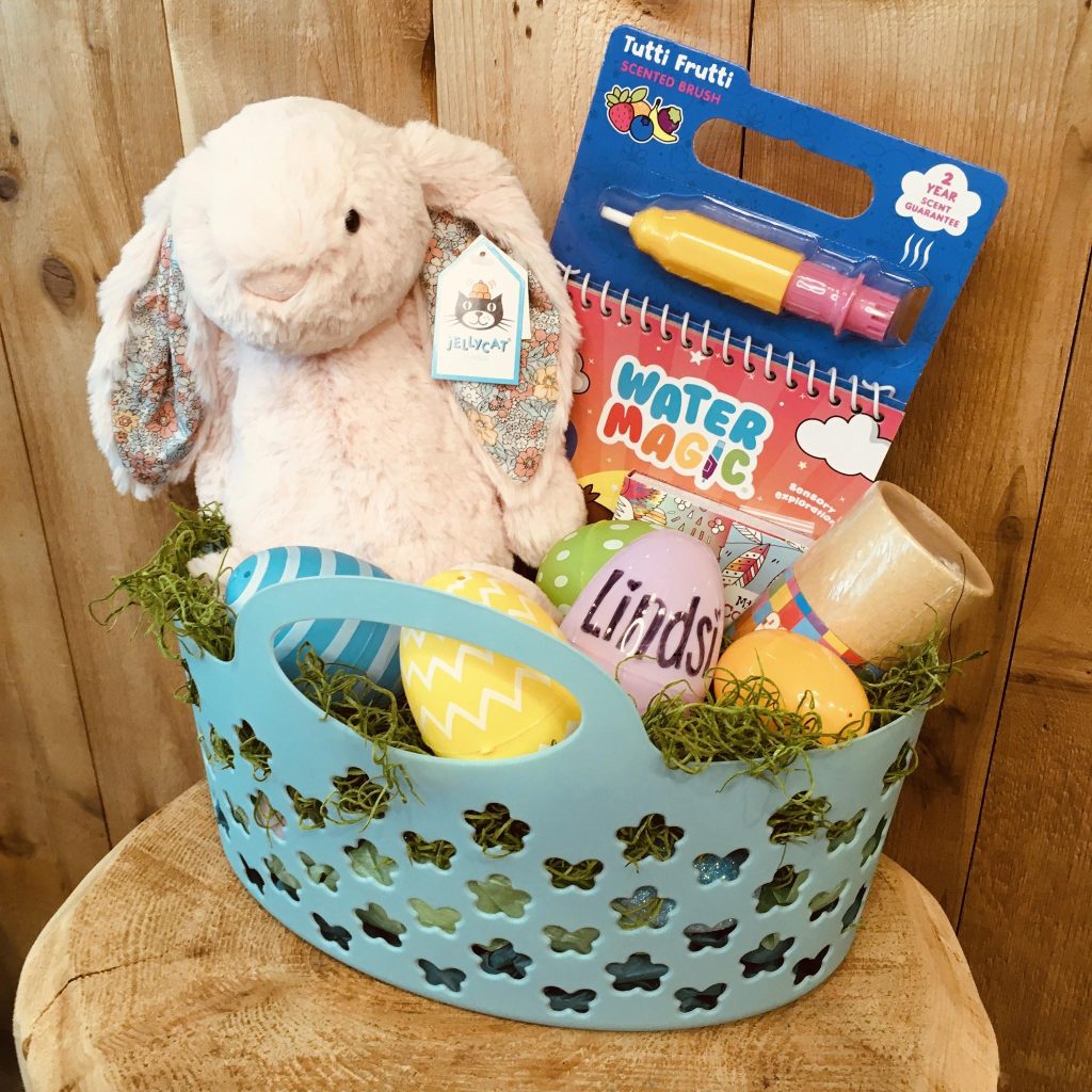 green basket filled with a stuffed bunny, and assorted games.