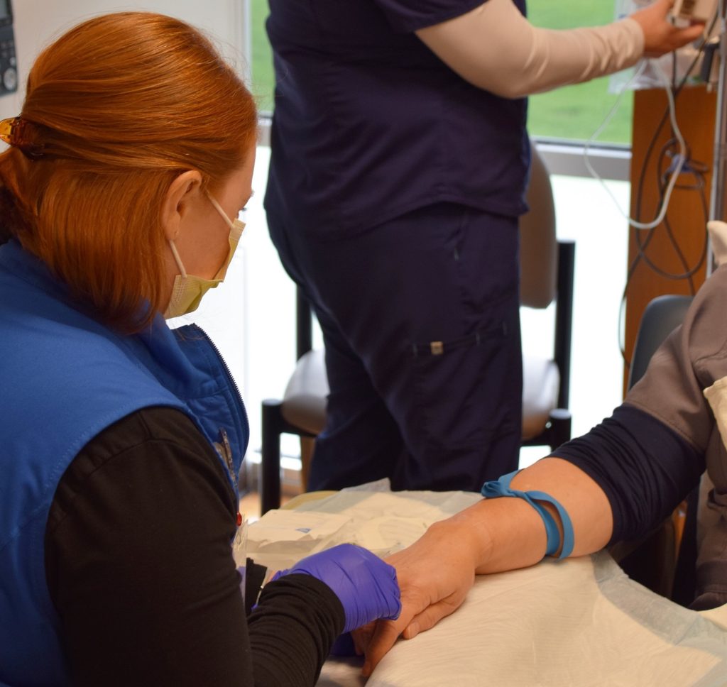arm of a person getting an IV put in by a nurse