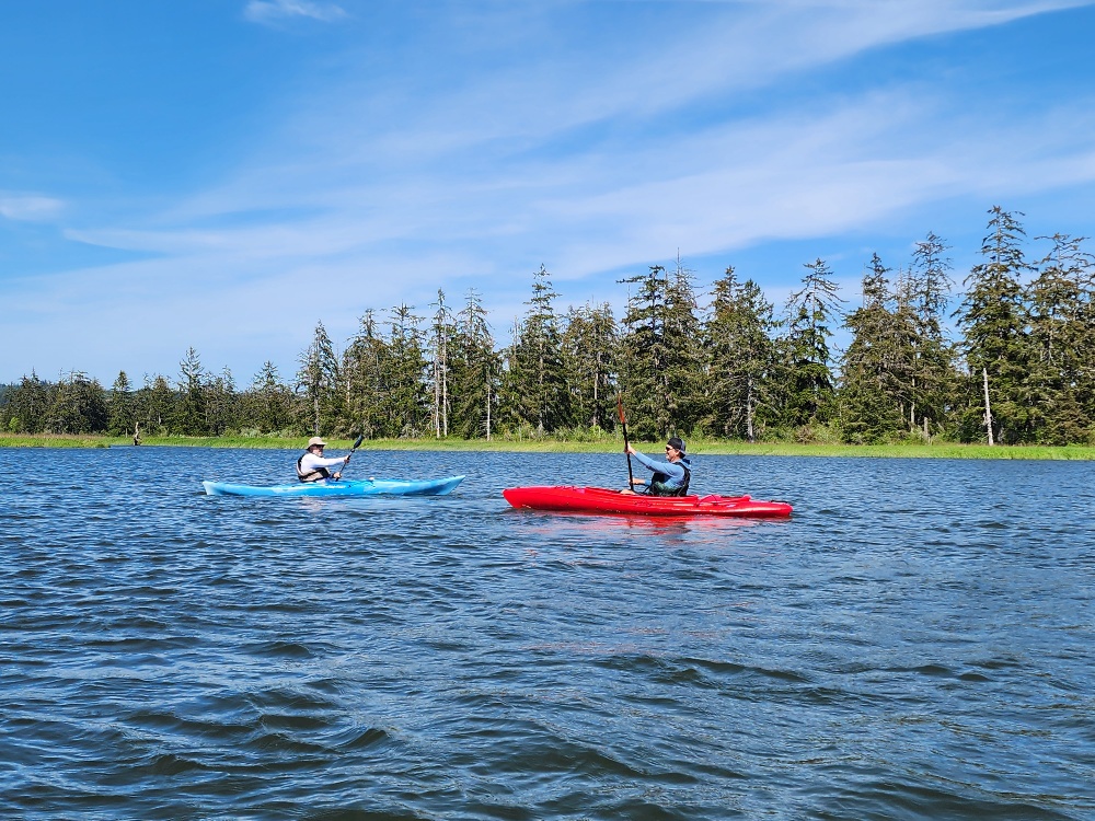 2 kayakers , one in a red kayak the other in a blue kayak on the Chehalis River