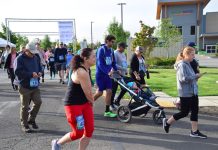 large group of women, men, and children running. Some with strollers