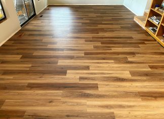 photo of an empty room with a textured vinyl plank floor that looks like wood