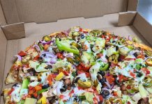 a large pizza with lots of toppings inside a cardboard box