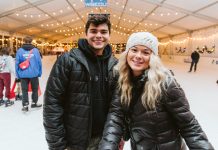 a man and woman pose for a picture inside the Oly on Ice rink