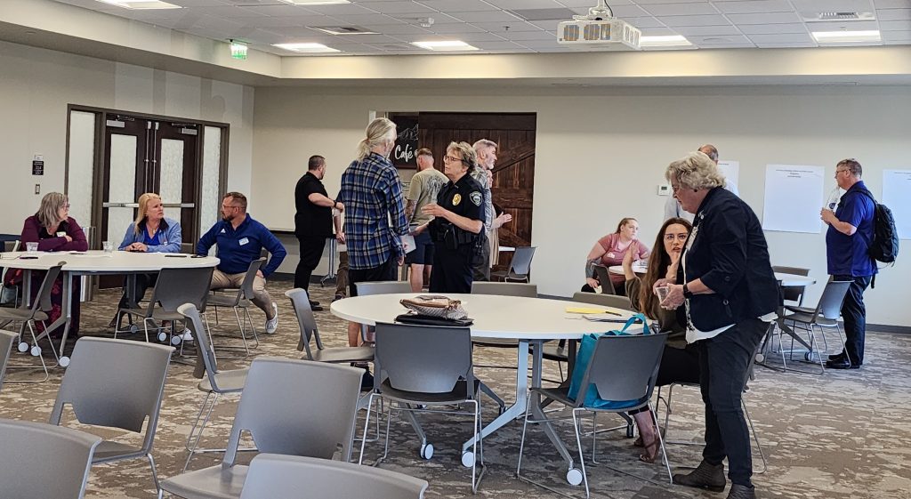 people standing around large, round tables, talking