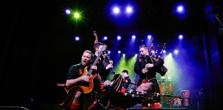 The Red Hot Chilli Pipers performing on stage with smoke and lights