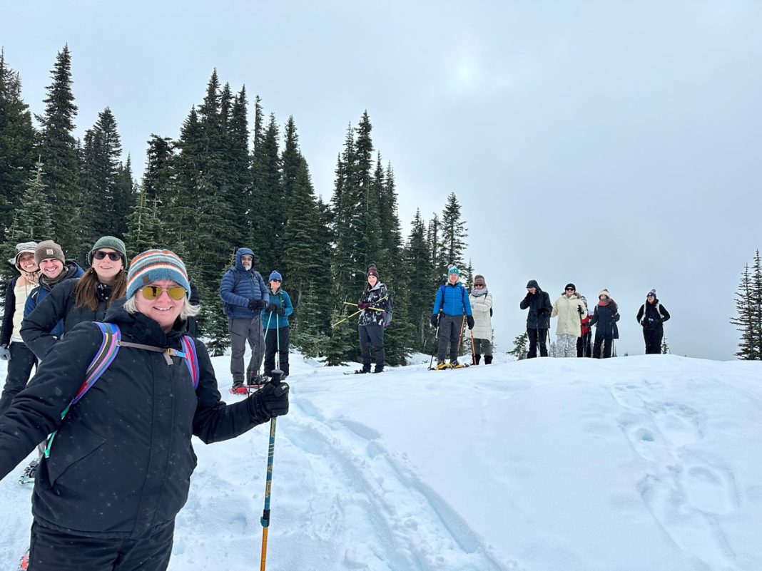 people in a line snowshoeing in deep snow